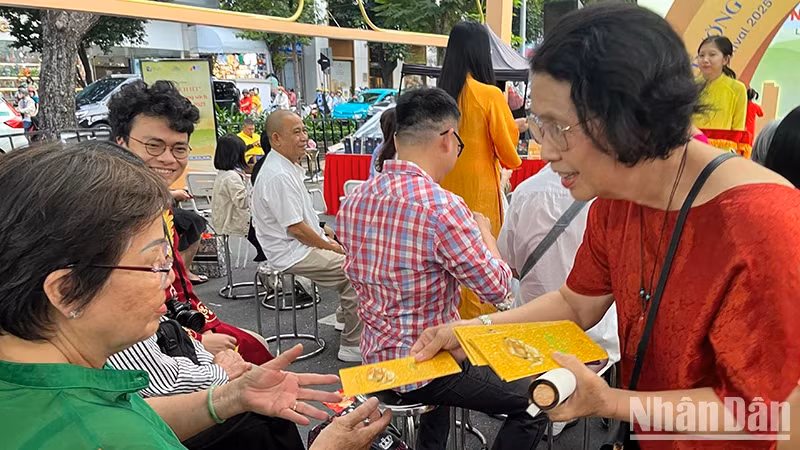 Dr Quach Thu Nguyet gives books to people attending the programme.