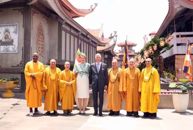 King Philippe and Queen Mathilde of Belgium take a group photo with monks at Vinh Nghiem Pagoda. (Photo: VNA)