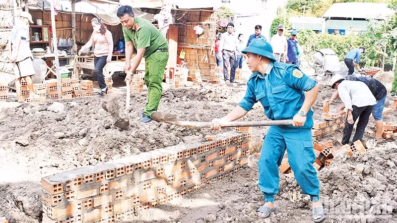 Armed forces and political organisations of Huyen Hoi Commune, Cang Long District, Tra Vinh Province, support people to build houses. (Photo: KHOI - GIANG)