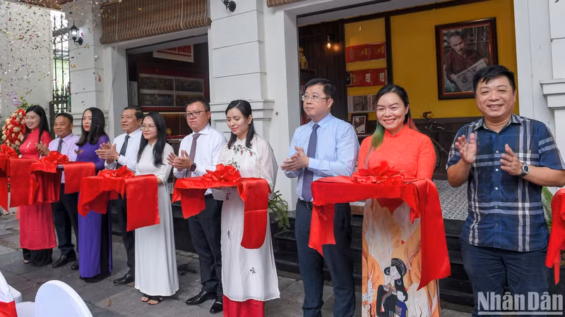 Delegates cut the opening ribbon to launch the exhibition space for experiencing and introducing products of Nhan Dan Newspaper.