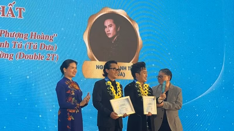 President of the Vietnam Women's Union Ha Thi Nga presents the First Prize to musician Nguyen Anh Tu for his song “Phoenix Wings”.