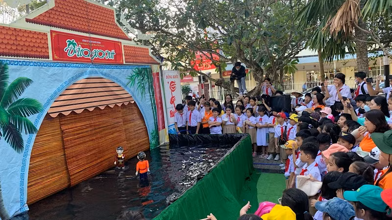 The water puppet show attracts a large number of young spectators.