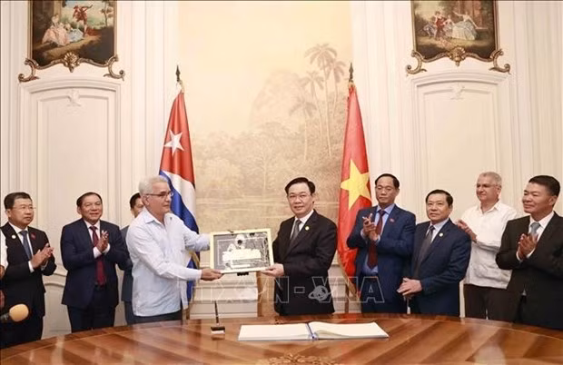NA Chairman Vuong Dinh Hue gives present to the centre. (Photo: VNA)
