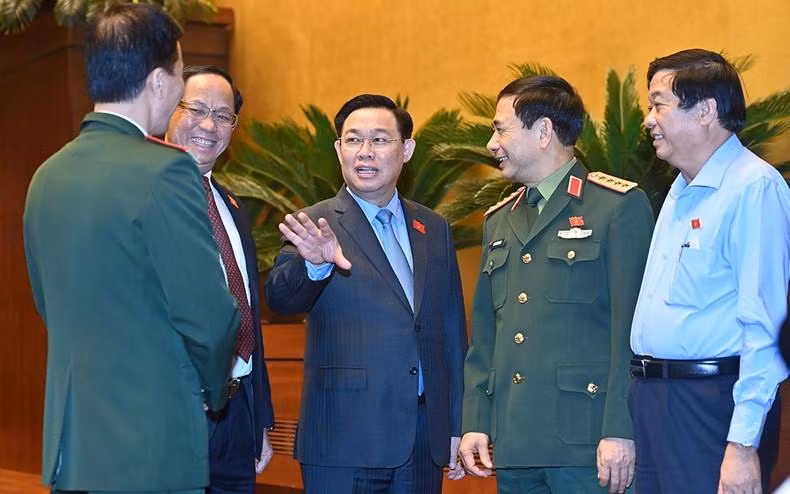 National Assembly Chairman Vuong Dinh Hue and delegates on the sidelines of the session to discuss the draft Law on Civil Defence.