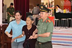 Police officers and officials from Giai Lac Commune assist relatives of martyrs at a DNA sample collection point. (Photo: NDO)