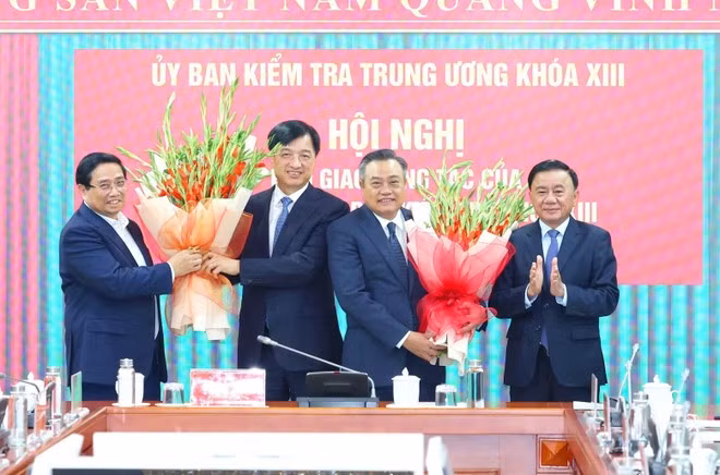 Prime Minister Pham Minh Chinh (first, left) and Permanent Member of the Party Central Committee’s Secretariat Tran Cam Tu (first, right) present flowers to congratulate Nguyen Duy Ngoc (second, left), former Chairman of the Party Central Committee’s Inspection Commission and now Secretary of the Ha Noi Party Committee, as well as Tran Sy Thanh (third, left), new Chairman of the Inspection Commission. (Photo: VNA)