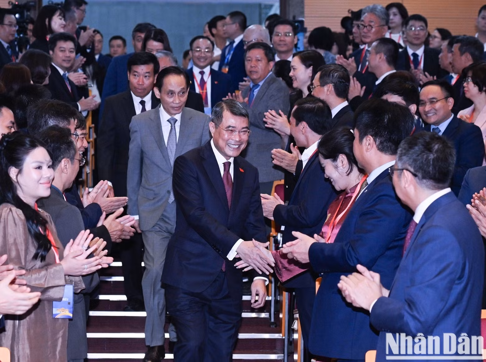 Prime Minister Le Minh Hung shakes hands with delegates attending the plenary session.