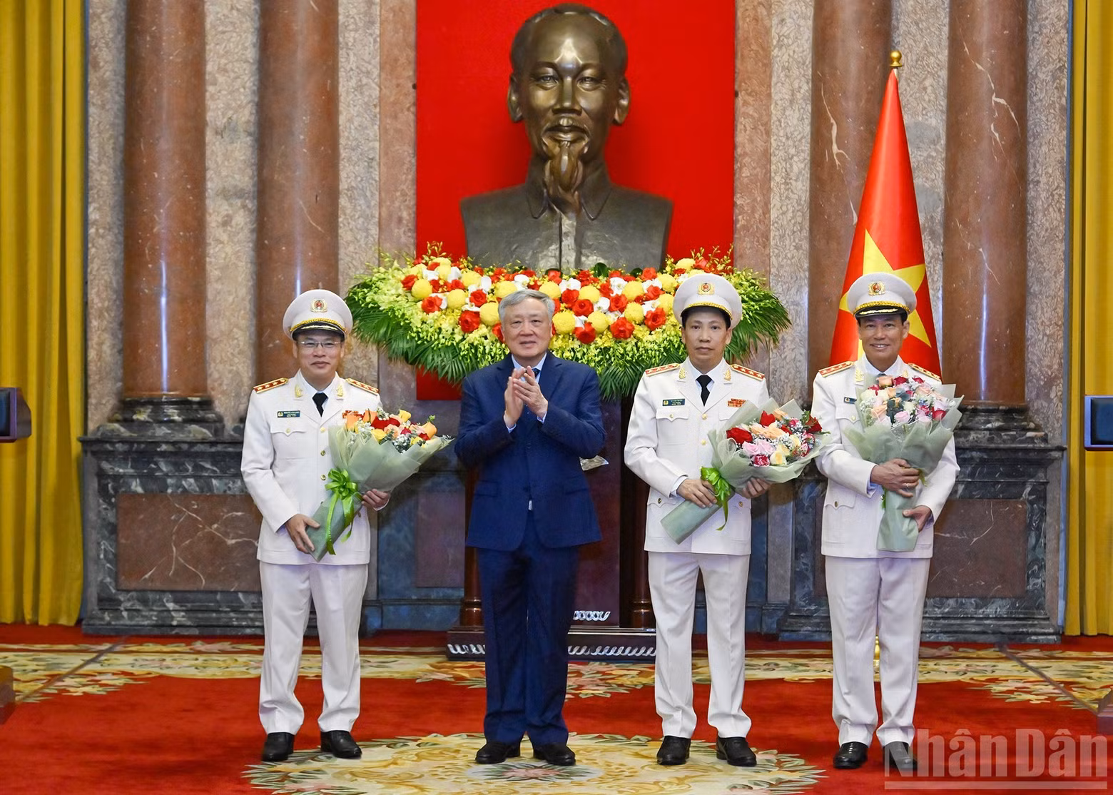 Permanent Deputy Prime Minister Nguyen Hoa Binh presents flowers to congratulate the three Deputy Ministers.