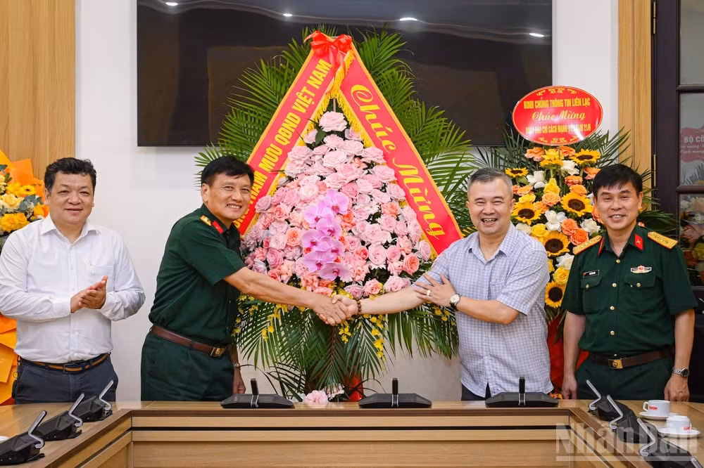 Dinh Song Linh, member of the Party Committee Standing Board and Head of the Science and Environment Department of Nhan Dan Newspaper, receives Colonel Pham Van Hung, Deputy Director of the Political Department of the General Staff of the Viet Nam People’s Army, and his delegation.
