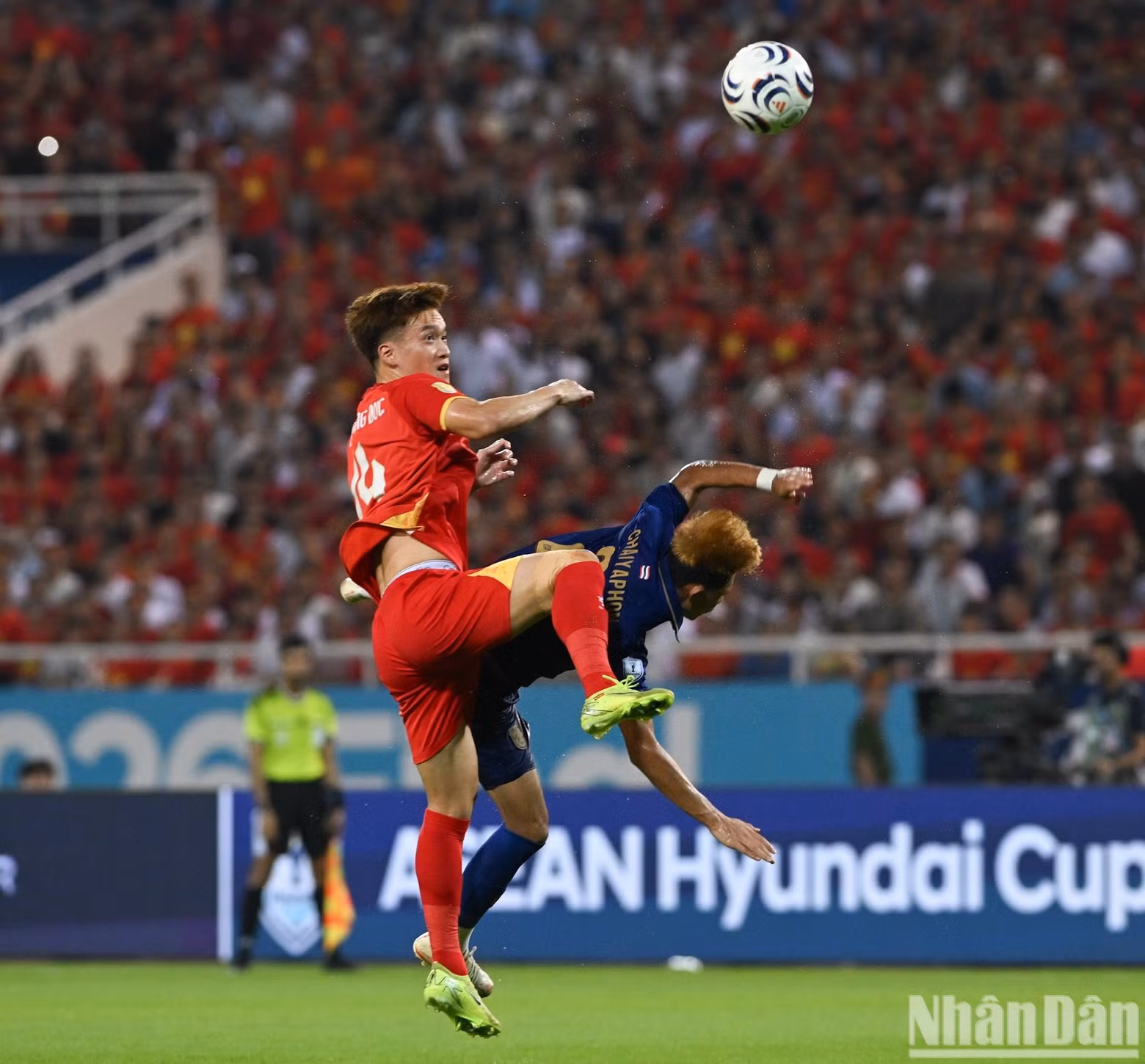 Hoang Duc challenges a Thai player for an aerial ball.