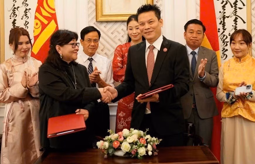 Ariunjoloo, Dean of the Faculty of Theatre Arts, representing the Mongolian State University of Arts and Culture, signs a cooperation agreement on training and research with director Le Quy Duong.