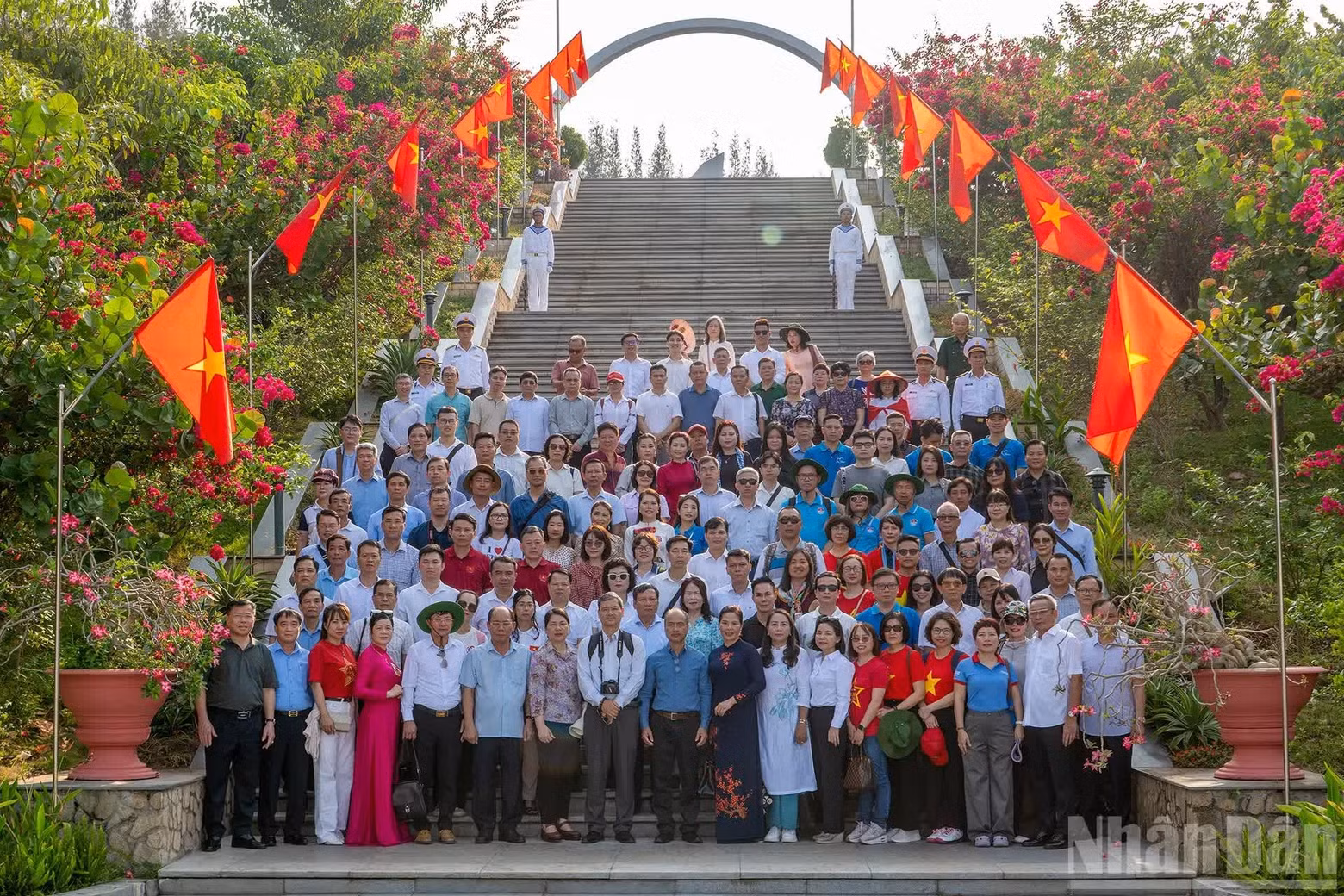 The delegation poses for a commemorative photograph in front of the memorial site.