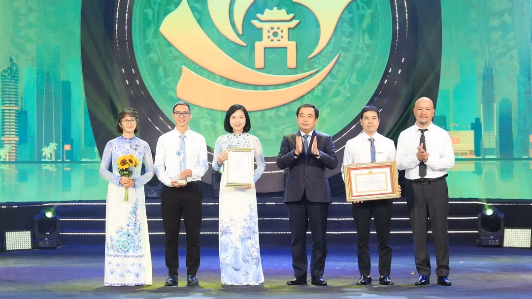 Secretary of the Ha Noi Party Committee Tran Duc Thang presents the special prize to a group of authors from the Ha Noi Newspaper and Radio-Television Agency. (Photo: Organising Committee)