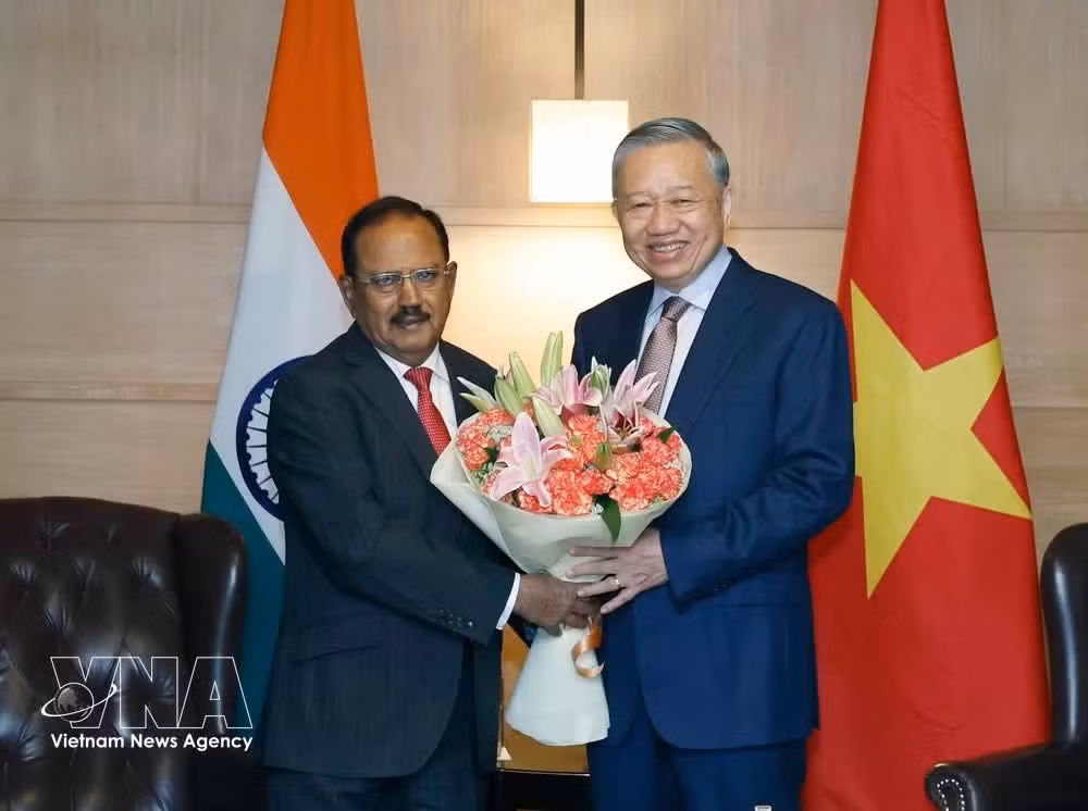 Indian National Security Advisor Ajit Doval (L) presents flowers to Party General Secretary and State President To Lam. (Photo: VNA)
